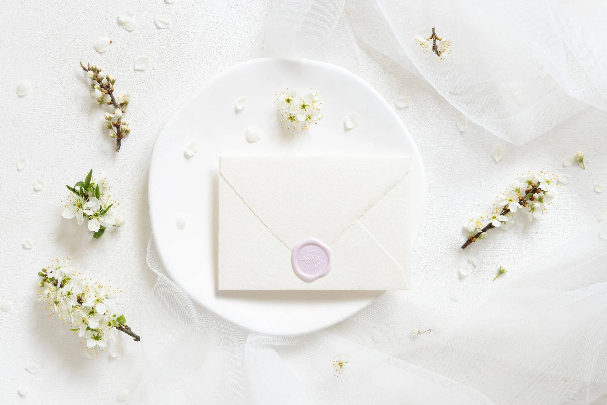 Sealed envelope on plate with soft floral details